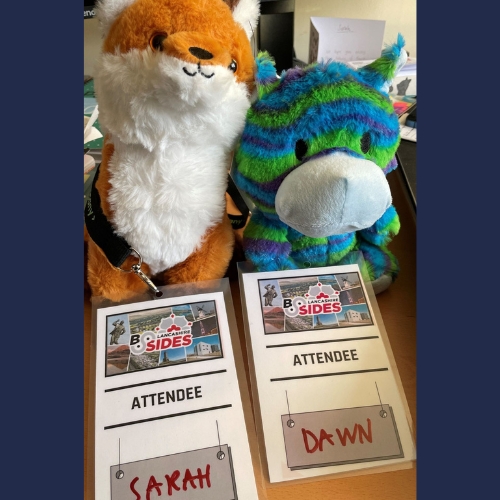 Cuddly toy fox and horse with event name tags in front on table