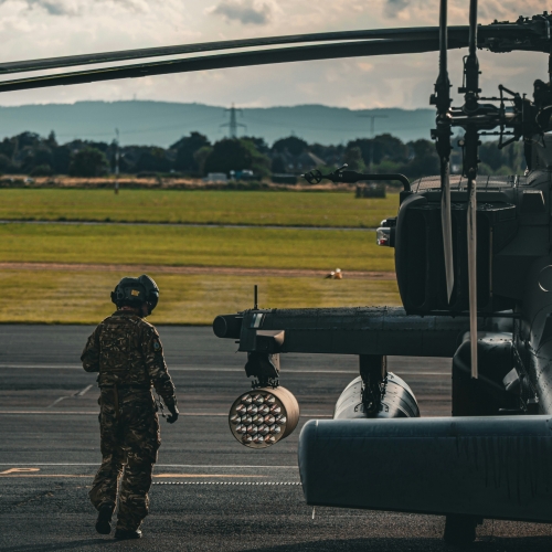 Soldier next to military helicopter on tarmac